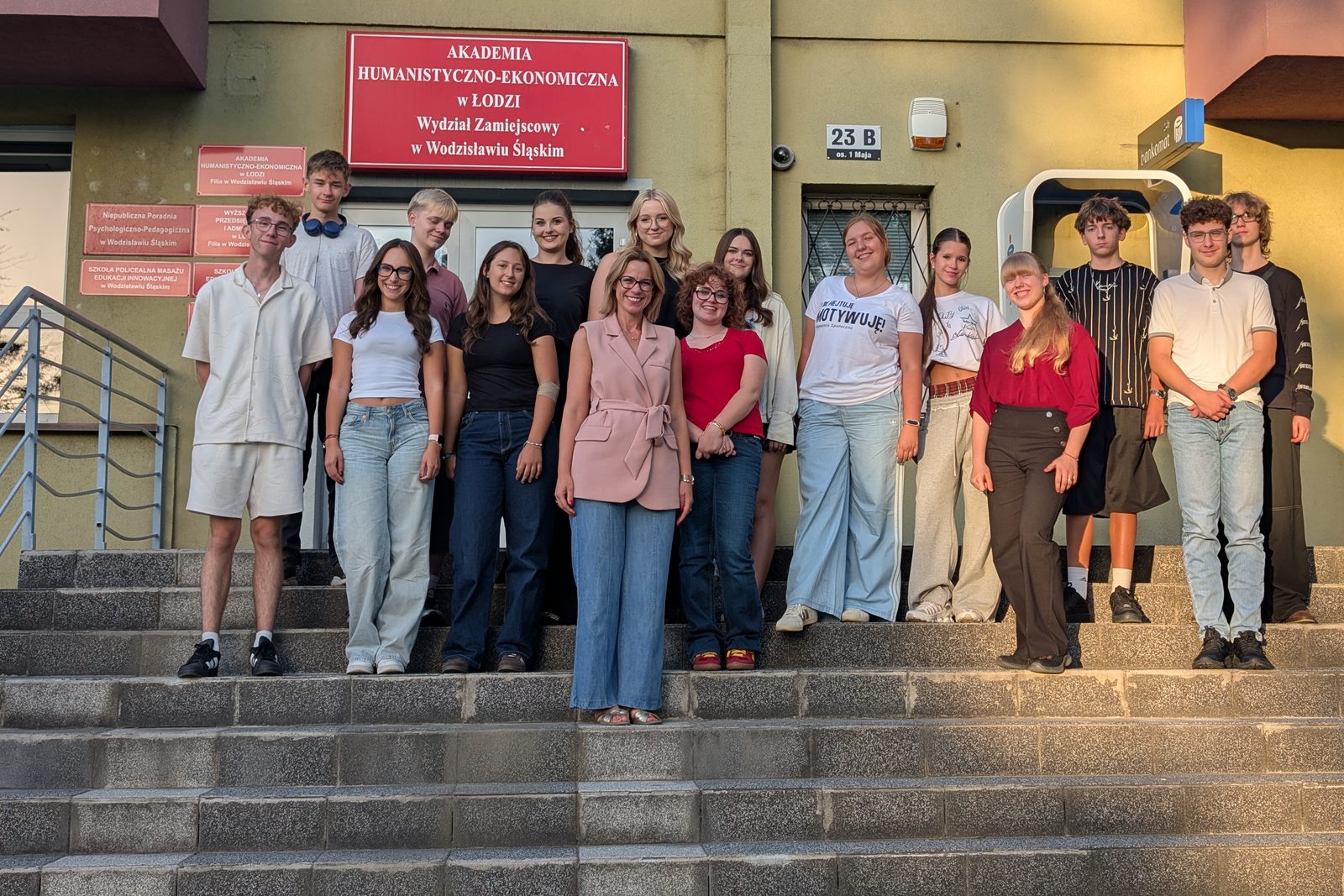 Uczestnicy warsztatów z prowadzącą na schodach przed budynkiem Akademii Humanistyczno-Ekonomicznej w Wodzisławiu Śląskim